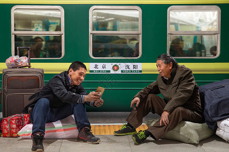 包平台素材两名男子在火车月台上看手机背景