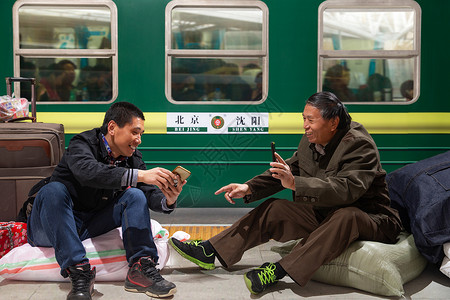 新年直播两名男子在火车月台上看手机背景