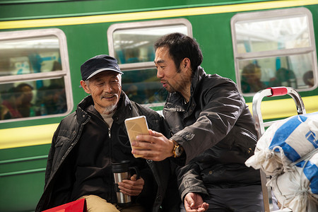 在火车站台上看手机的旅客图片
