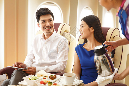 安全用餐年轻夫妇在飞机上用餐背景