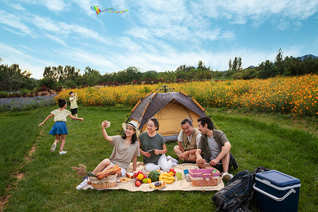 互联网生态峰会快乐的一家人在郊外野餐背景