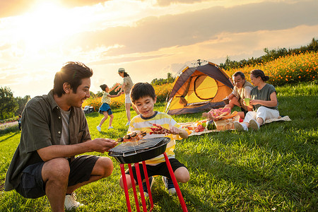 烧烤的男孩欢乐的一家人在郊外野餐烧烤背景
