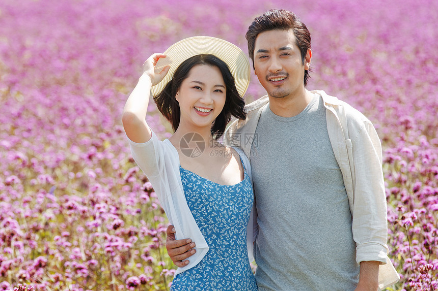 幸福的青年夫妇站在花海里图片