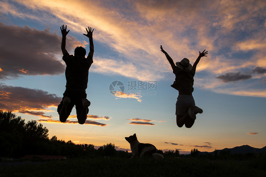 夕阳下跳跃的快乐夫妇图片