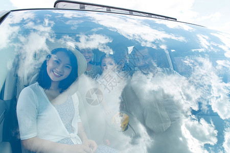 玻璃外天空坐在汽车里的幸福一家人背景