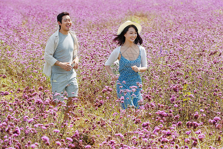 在麦田里奔跑的情侣青年夫妇在花海里奔跑背景