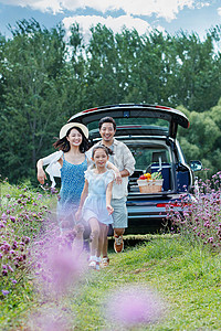 在花海里奔跑的幸福家庭高清图片