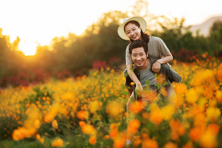 花丛中的男人花丛中幸福的青年夫妇背景