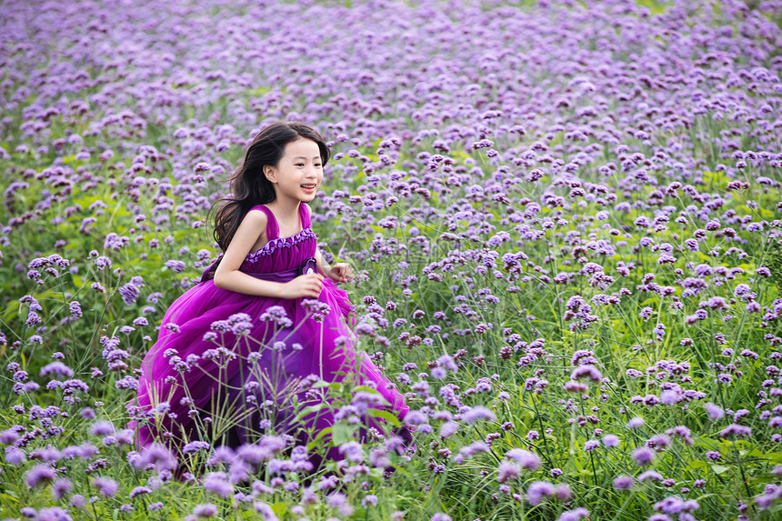 快乐的小女孩在花海里奔跑图片