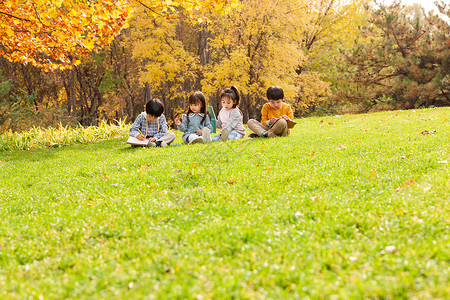 可爱的小朋友们坐在草地上写字图片