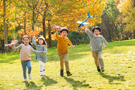飞机跑到拿着玩具飞机在公园玩耍的快乐儿童背景