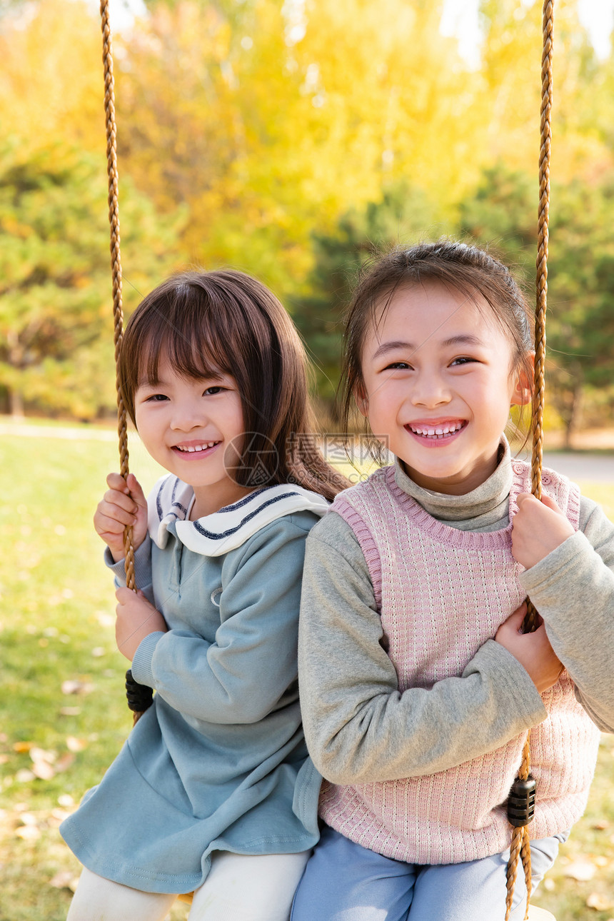 两个女孩在公园里荡秋千图片