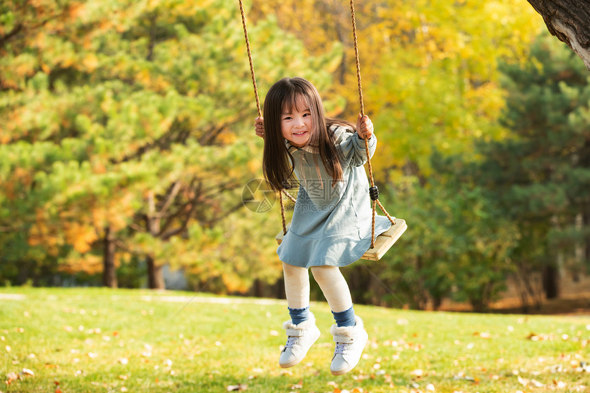 在公园里荡秋千的快乐女孩图片