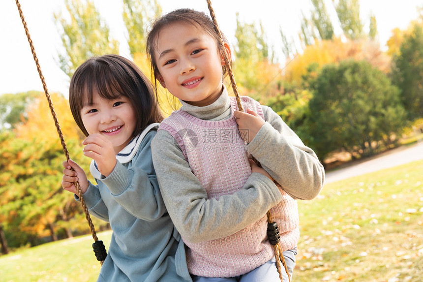 两个女孩在公园里荡秋千图片