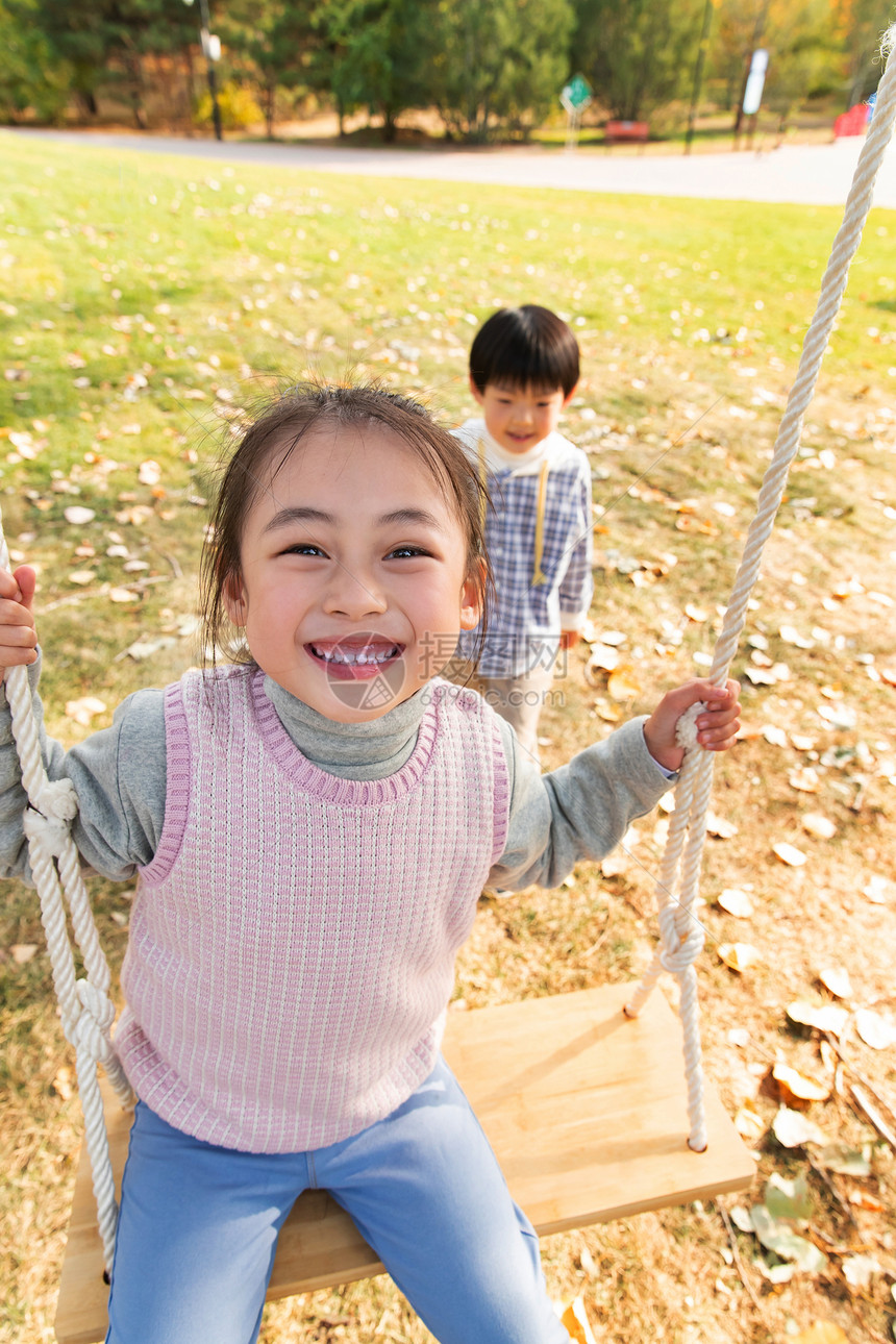在公园里荡秋千的快乐儿童图片
