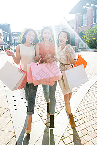 阳光下时尚的年轻女孩们购物逛街图片