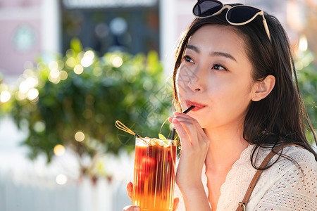 喝饮料的太阳快乐的青年女人品尝夏日饮品背景