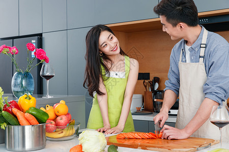切橙子男人在厨房做饭的幸福情侣背景