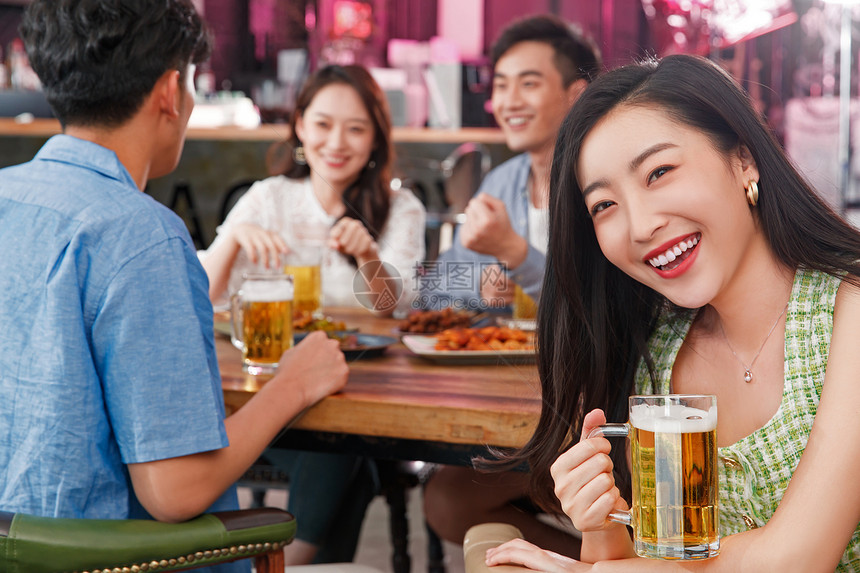 青年女人和朋友在酒吧喝酒图片