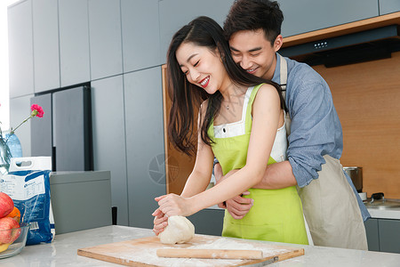 青年夫妇在厨房做面食高清图片