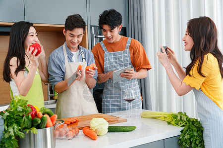 快乐的年轻人在厨房做饭照相高清图片