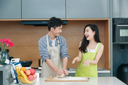 头顶苹果情侣青年夫妇在厨房做面食背景