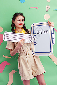 饼干写字框年轻女孩拿着铅笔和笔记本背景