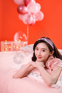 红色清新气球趴在床上的漂亮年轻女孩背景