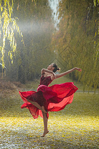 美女在红色穿红色裙子的青年女人在户外跳芭蕾舞背景