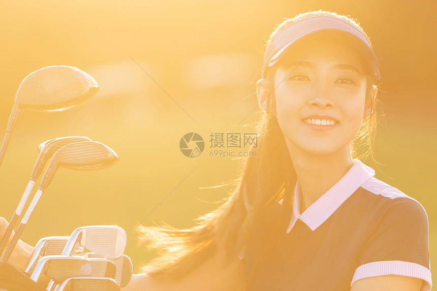 快乐自信的打高尔夫的青年女人图片