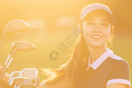 快乐自信的打高尔夫的青年女人图片