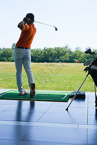 高尔夫练习场上青年男人打高尔夫图片