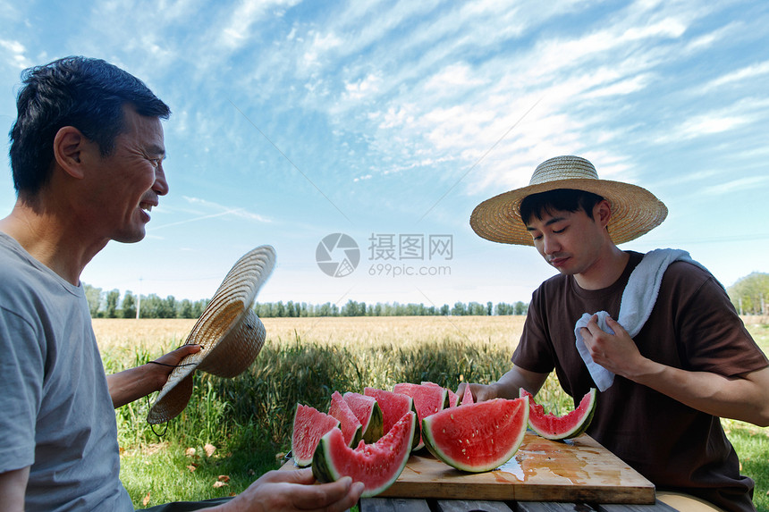 农民在田地旁休息吃西瓜图片