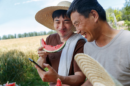 农民在田地旁休息吃西瓜高清图片