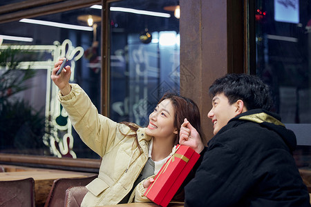 冬季年轻情侣拿着礼物自拍高清图片