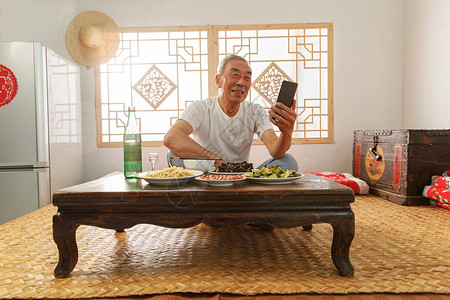 老年人坐在家里吃饭看手机背景
