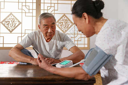 关注自闭症元素老年夫妇在家量血压背景