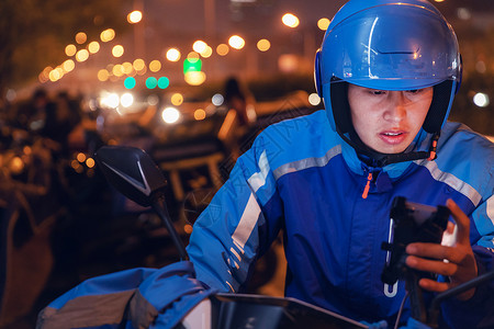 摩托车灯使用手机的外卖员背景