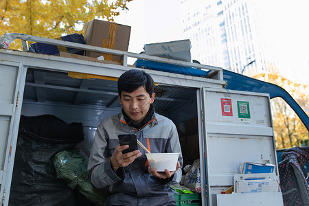 快递员坐在快递车上休息图片