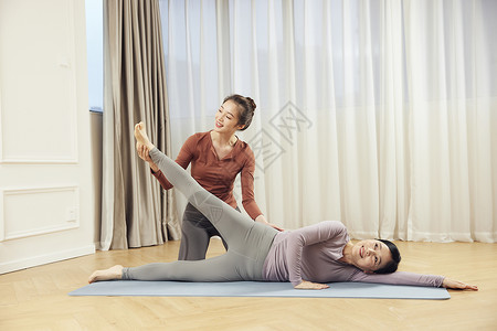 美女居家运动锻炼年轻美女指导母亲瑜伽运动背景