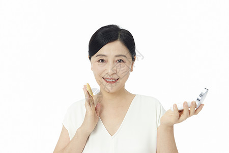 中年气质美女使用粉扑化妆背景图片