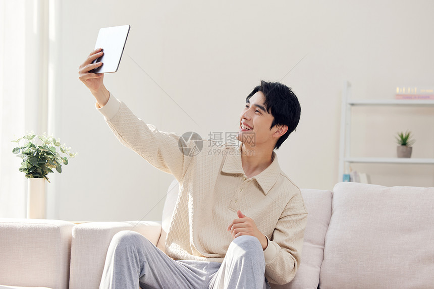 居家手拿平板电脑facetime的男性图片