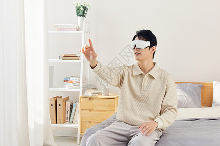 男性坐在床上操作vr虚拟屏幕高清图片
