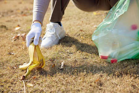 捡垃圾的地球捡拾草地上的香蕉皮背景