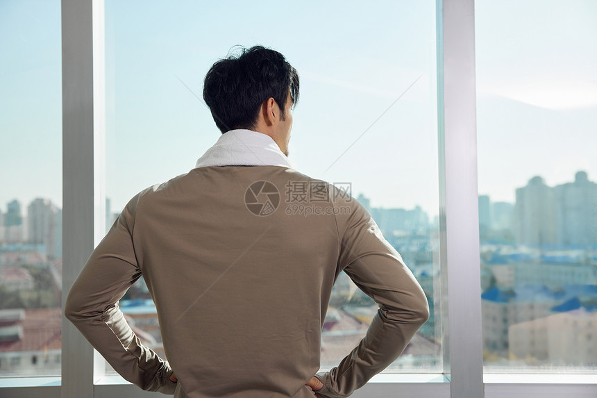 运动男性晨练完看窗外风景图片