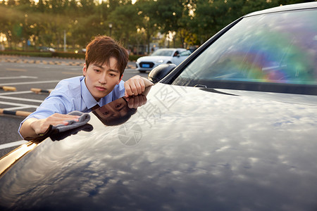 车漆面白领男性擦拭汽车外部漆面背景
