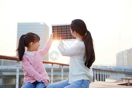 妈妈带女儿户外体验太阳能板高清图片