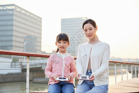 户外展示发电风车的母女背景图片