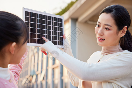 妈妈带女儿户外体验太阳能板背景图片