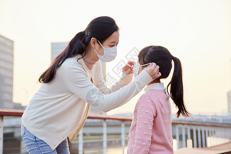 健康小孩素材户外妈妈帮女儿戴口罩背景